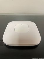 Front view of the white Cisco Aironet 3500 wireless access point showing square shape and raised central logo panel with LED indicator.