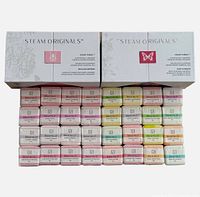 Two sealed boxes of Steam Originals shower steamers with various blends stacked showing the packaging and label detail.