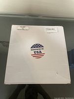 White box with 'Renewed in USA' sticker visible on top, showing the packaging condition.