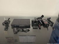 PlayStation 2 console, controller, HDMI adapter, USB drive, power adapter, and cables arranged on a table