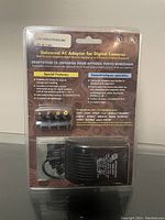 Image of the front and back packaging of the universal AC adapter showing compatibility details, features, and specifications.