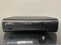 Front view of the black Xbox 360 console showing the disc tray, power button and eject button.