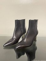 Side angle view of Zara ankle boots showing black leather upper, elastic side panels and reflective metal block heels.