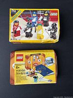 Top view of two sealed LEGO boxes, one yellow Legoland Space box and one yellow LEGO suitcase box