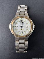 Front view of vintage Guess watch showing white dial, stainless steel case and band with signs of wear.