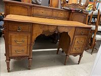 Full front view of the desk showing two pedestal drawer banks and central knee-hole with small drawers