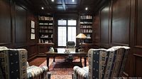Assembled desk in office with paneled walls and built-in bookshelves