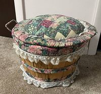Photo of the closed round woven wood sewing basket with padded floral fabric lid and lace trim