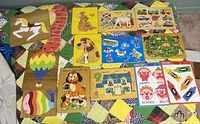 Top view showing multiple colorful wooden preschool puzzles grouped on quilt.
