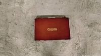 Closed brown carrying case with Crayola logo on top.