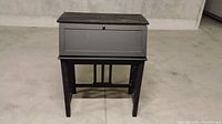 Antique wooden desk closed showing dark finish and simple design.