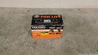 Box of Ridgid cordless drill and impact driver combo kit showing front with compatibility and service information
