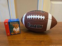 Photo of Franklin football and NFL Powerplay Teddies ceramic figurine box on wooden surface.