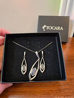 Photo of new unworn Tocara necklace and matching earrings in black presentation box, showing full set and packaging.