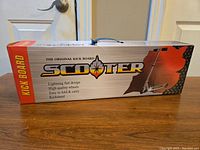 Full box of the scooter showing branding, folded scooter graphics, and features.