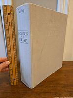Front cover and spine of large hardcover book titled Paintings In The Louvre by Coving, with a ruler for size reference.