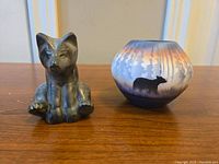 Photo showing front view of the soapstone bear and the pottery vase with forest and bear design on the front.
