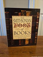 Front cover of The Smithsonian Book of Books showing the title and a collection of old books on the dust jacket.