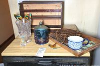 Photo of the carnival glass covered jar, glass vase, small toothpick holder with toothpicks, vegetable basket hanger, wooden spice rack, and a tray with blue and white cup
