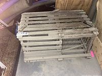 Side and top views of a vintage wooden lobster crate showing weathered wood slats and wire mesh sides used for trapping lobsters.