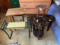 Overall view of all items including four wooden plant stands and one metal framed bench with padded yellow seat.
