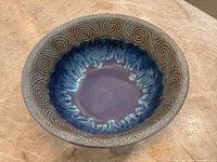 Top view showing deep blue and purple Raku glaze with carved spiral pattern on rim.