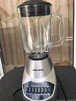 Front view of blender showing glass jar, lid, stainless base