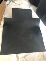 Full view of black chair mat on floor showing shape and surface