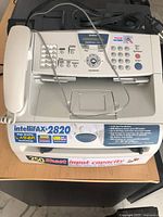 Top angle of Brother IntelliFAX-2820 showing control panel, branding, handset and cords