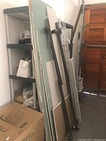 Stack of green and white drywall sheets leaning against wall