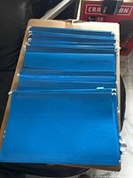 Stack of blue hanging folders showing metal rails