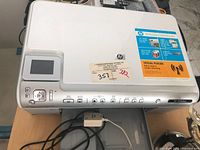 Top view of HP Photosmart C6300 printer showing control panel, scanner lid and attached cable