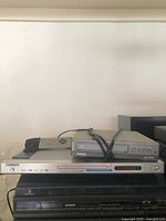 Front view of Kenwood DVD player with accompanying remote control visible