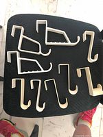 Seven white plastic over-the-door hangers on chair