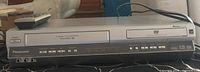 Front view of Panasonic DVD/VHS combo player with remote on top