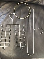 All three metal tie hangers laid out: chrome 12-hook rack, chrome vertical double-rod hanger, gold-tone circular ring