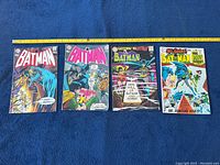 Overview of four Batman comics (#221, #222, #202, #208) laid flat with measuring tape
