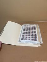 Folder open with multiple sheets of Canadian stamps in plastic sleeves