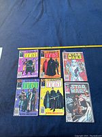 Front view of six Marvel Star Wars comics laid out on dark fabric, including Return of the Jedi series and additional issues, with a tape measure showing roughly 8-inch comic width