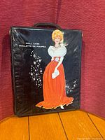 Front of black patent vinyl case with printed illustration of blonde woman in red gown