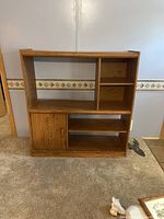 Front view of the entertainment center showing all compartments with door closed and the top hole visible.