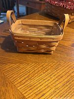 Front and top view of the small rectangular wooden basket with handles showing weave pattern and finish.