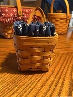 Front view of 1999 Longaberger basket with blue fabric liner and handle on a wooden surface.