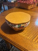 Closed view of the Longaberger fabric basket liner with wooden lid on wooden table.