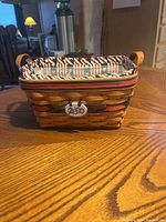 Front view of rectangular woven Longaberger basket with patriotic fabric liner inside.
