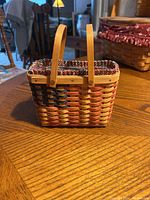 Front view of the woven Longaberger basket showing the American flag color pattern and the two natural wood handles.