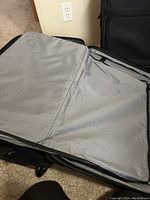 Interior open view of one luggage bag showing light grey lining and large zippered mesh compartment