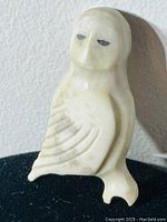 Front view of the owl pin showing carved details and eye markings