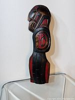 Front side wood carved wall plaque depicting an eagle and salmon design in red and black colors.