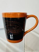 Side view of the vintage stoneware mug showing orange and black whale design with signature style indigenous Pacific Northwest Coast art.